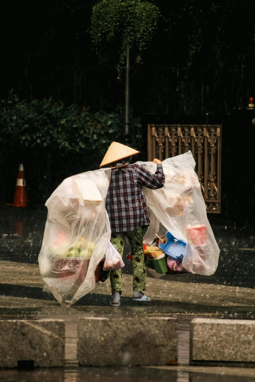 a man with several bags, in the rain