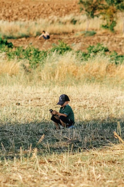 the  sits in the grass with a baseball bat