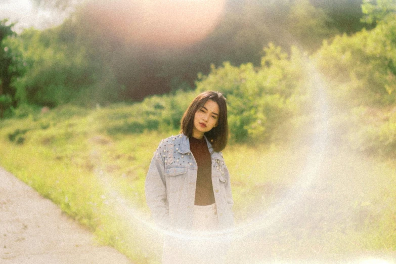 a woman in jeans jacket and tie standing by the road