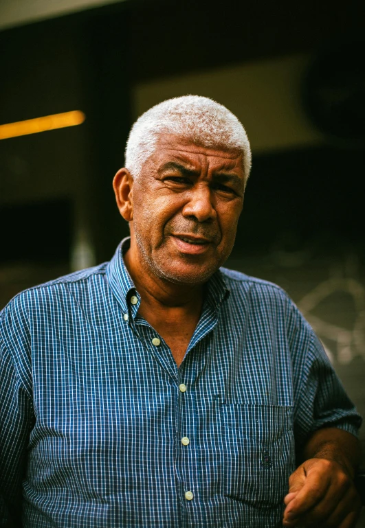 a man wearing a blue shirt holding a cigarette