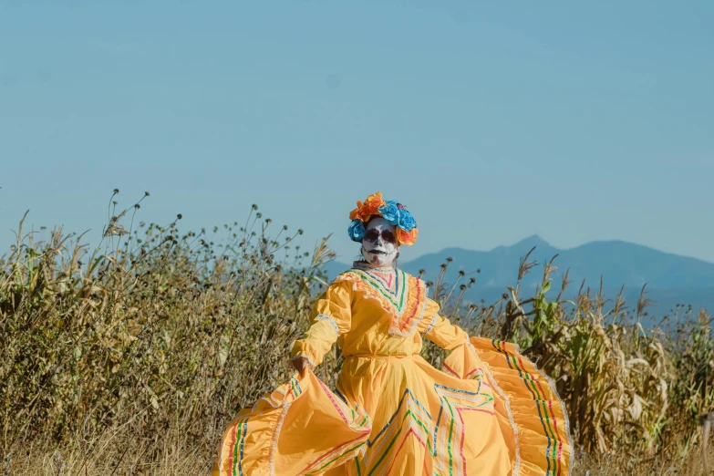 woman in dress walking on dirt path in open area