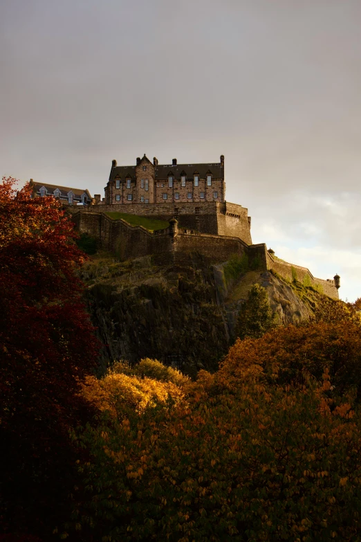 a castle on a cliff that is on a cloudy day