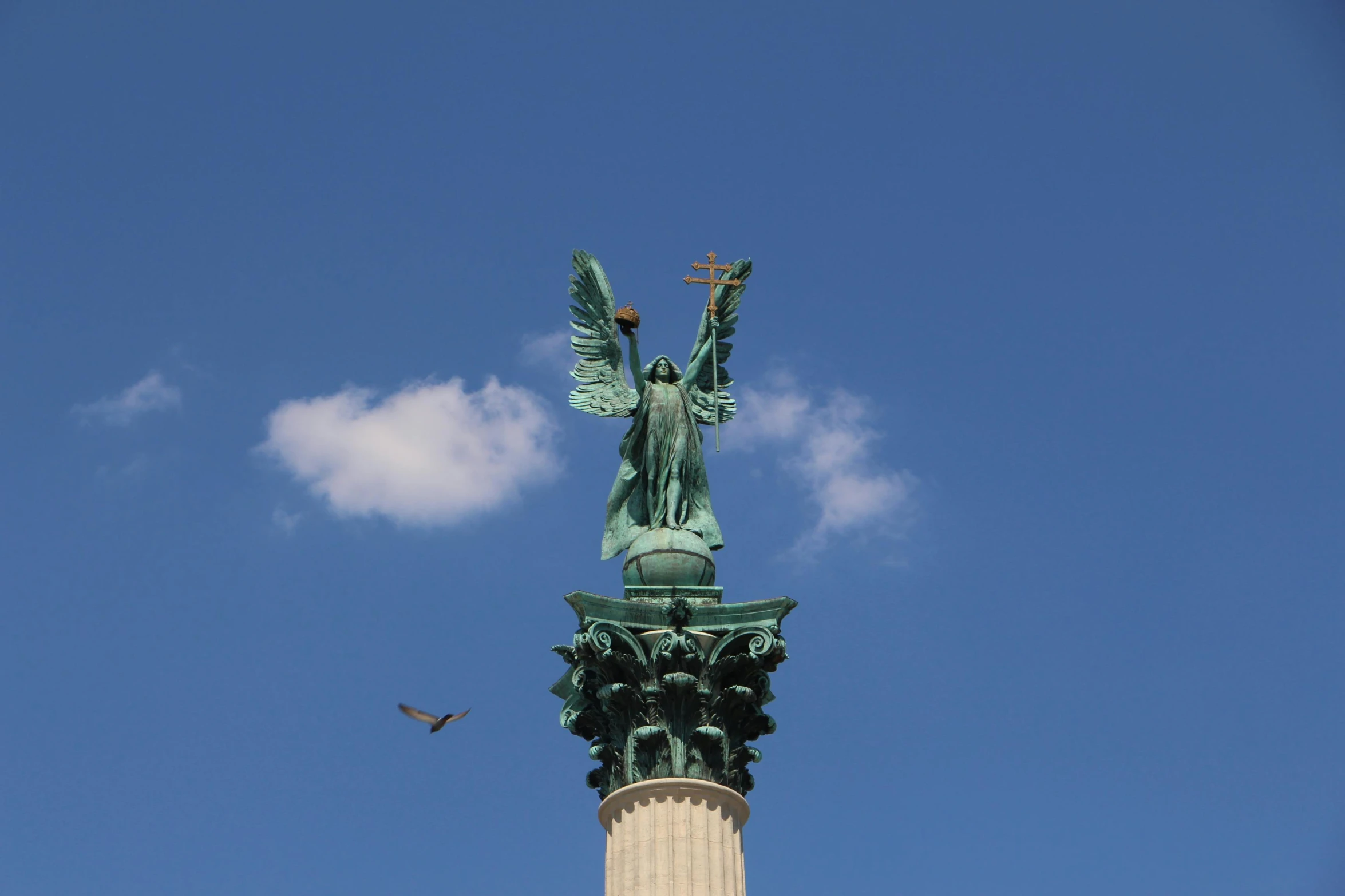 a statue on top of the monument with a sky background