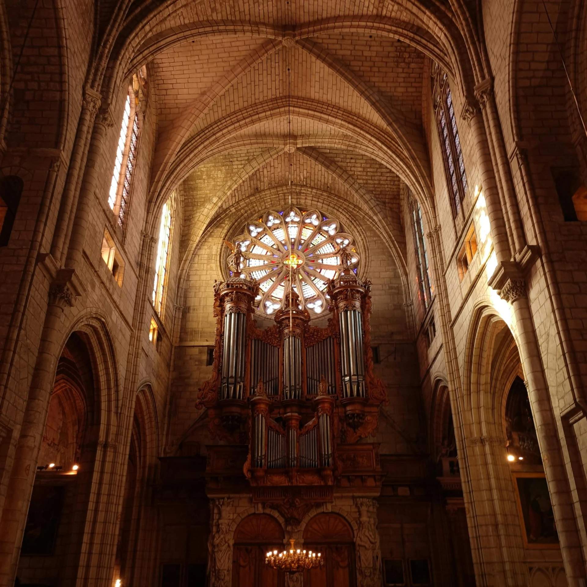 a cathedral with an ornate organ and chandelier