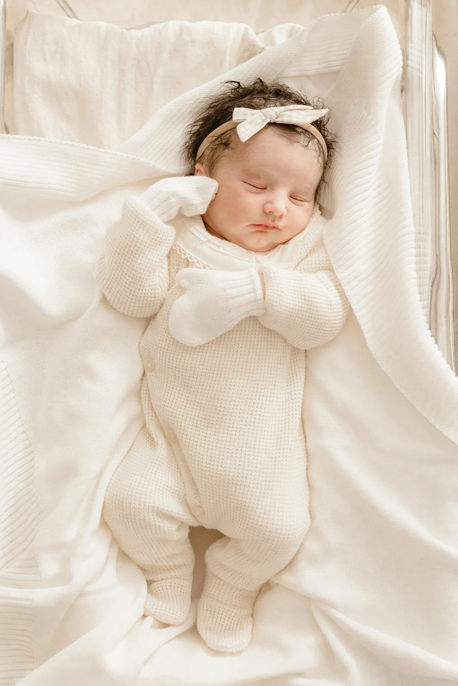 a baby sleeping on top of a white blanket