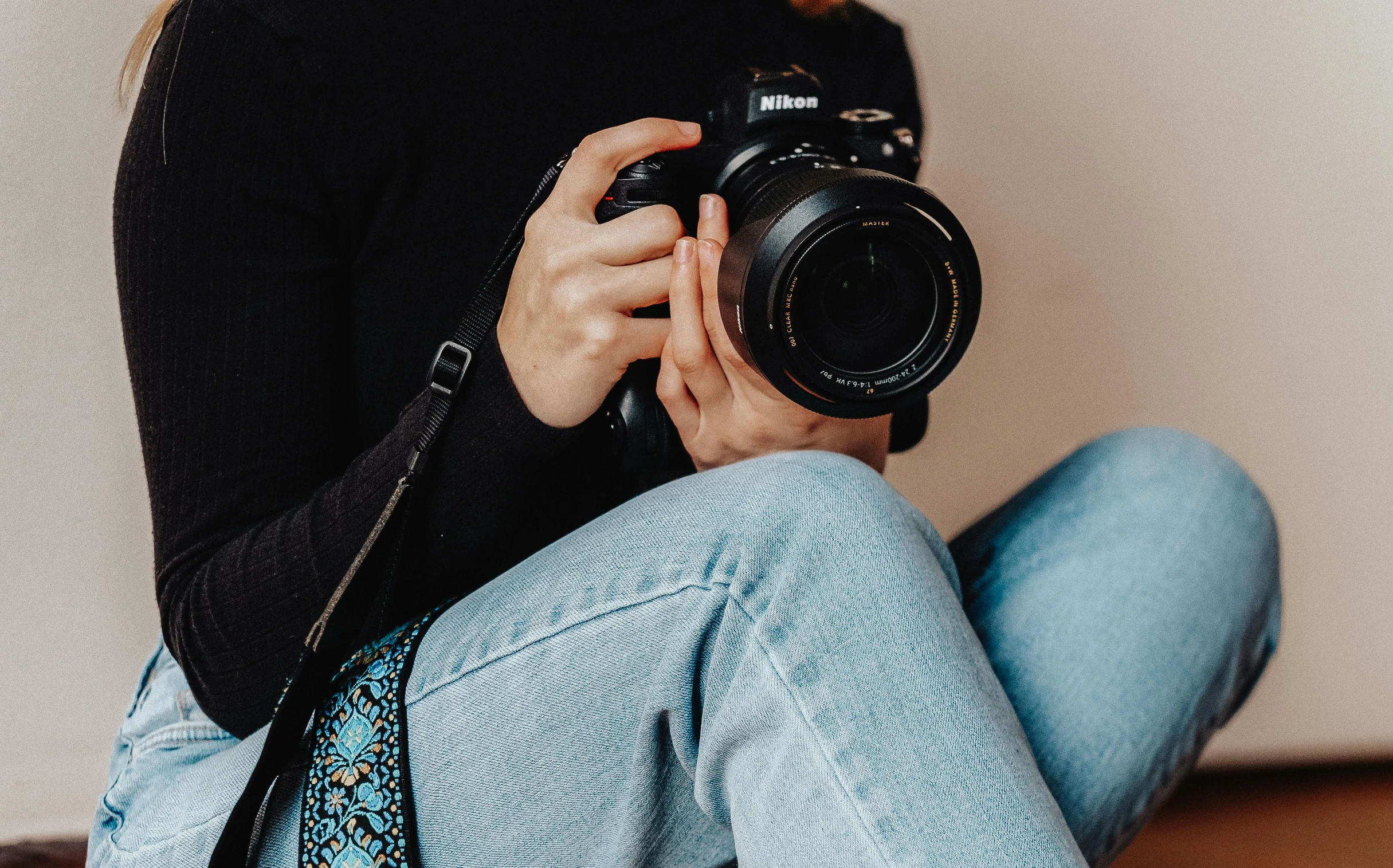 a person sitting with a camera and taking a picture