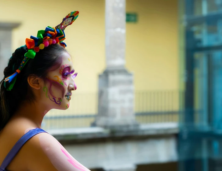 a woman with colorful makeup has her hair in a bun