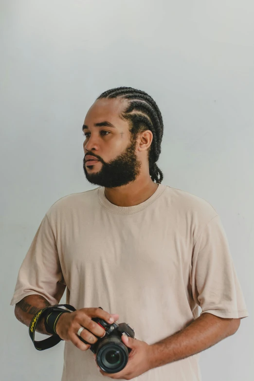 a man with dreadlocks, beard and camera