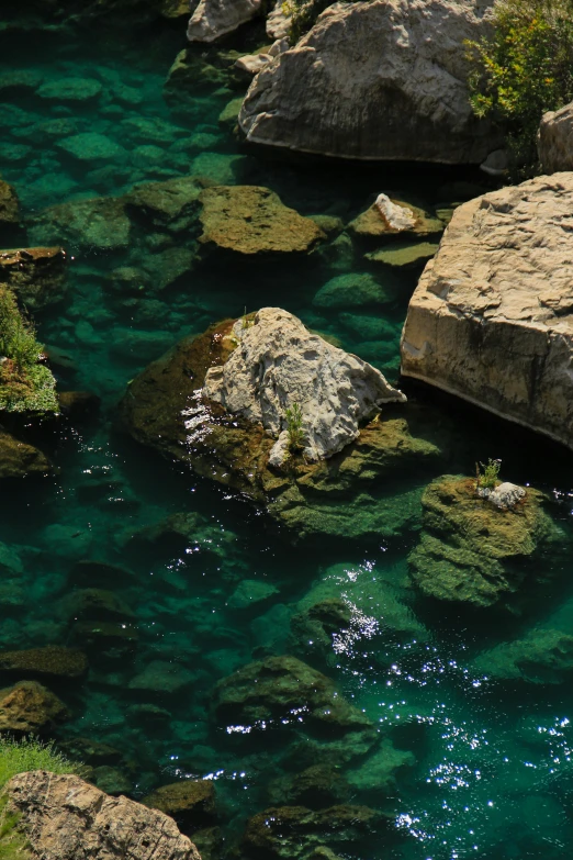 green, blue and clear waters surrounded by boulders