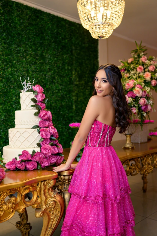 a beautiful young woman standing in front of a cake