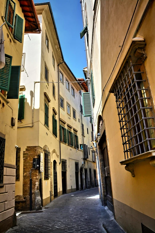 an alley with buildings and shutters on either side