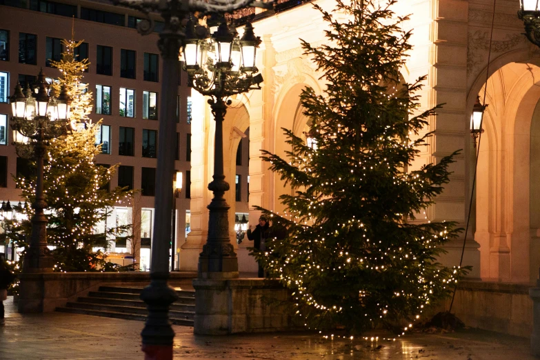 a tall christmas tree in a building plaza