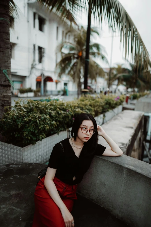 a woman sitting on top of a cement wall