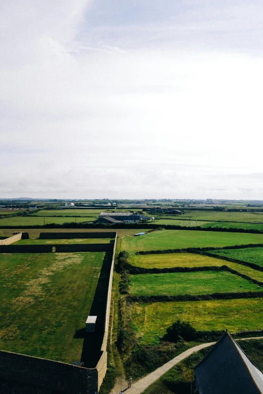 an empty field with many square buildings and a church