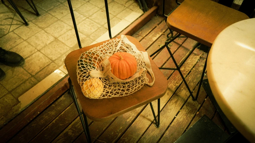 two pumpkins sit on top of the small chair