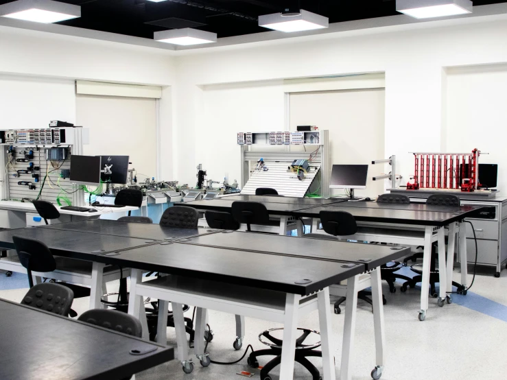 a classroom with black tables and chairs in it