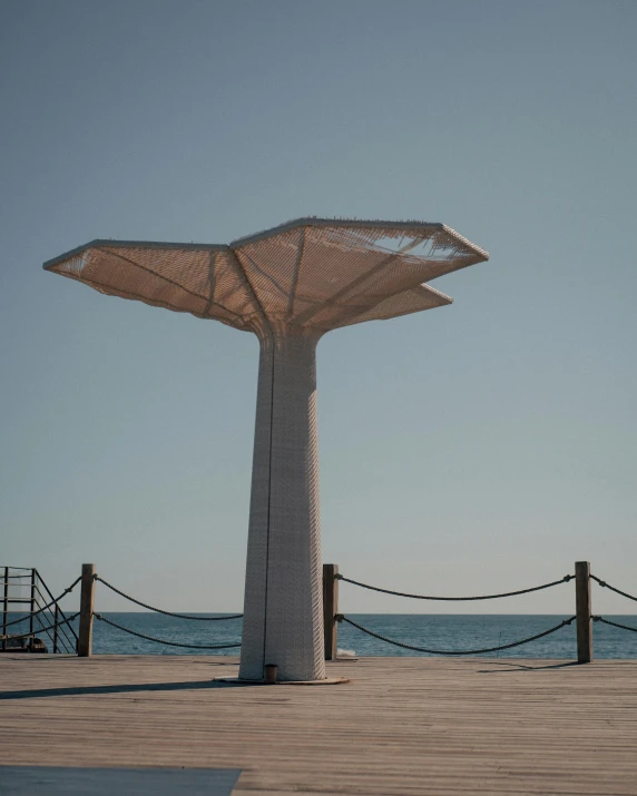 a white structure standing near the ocean with its bottom section cut open