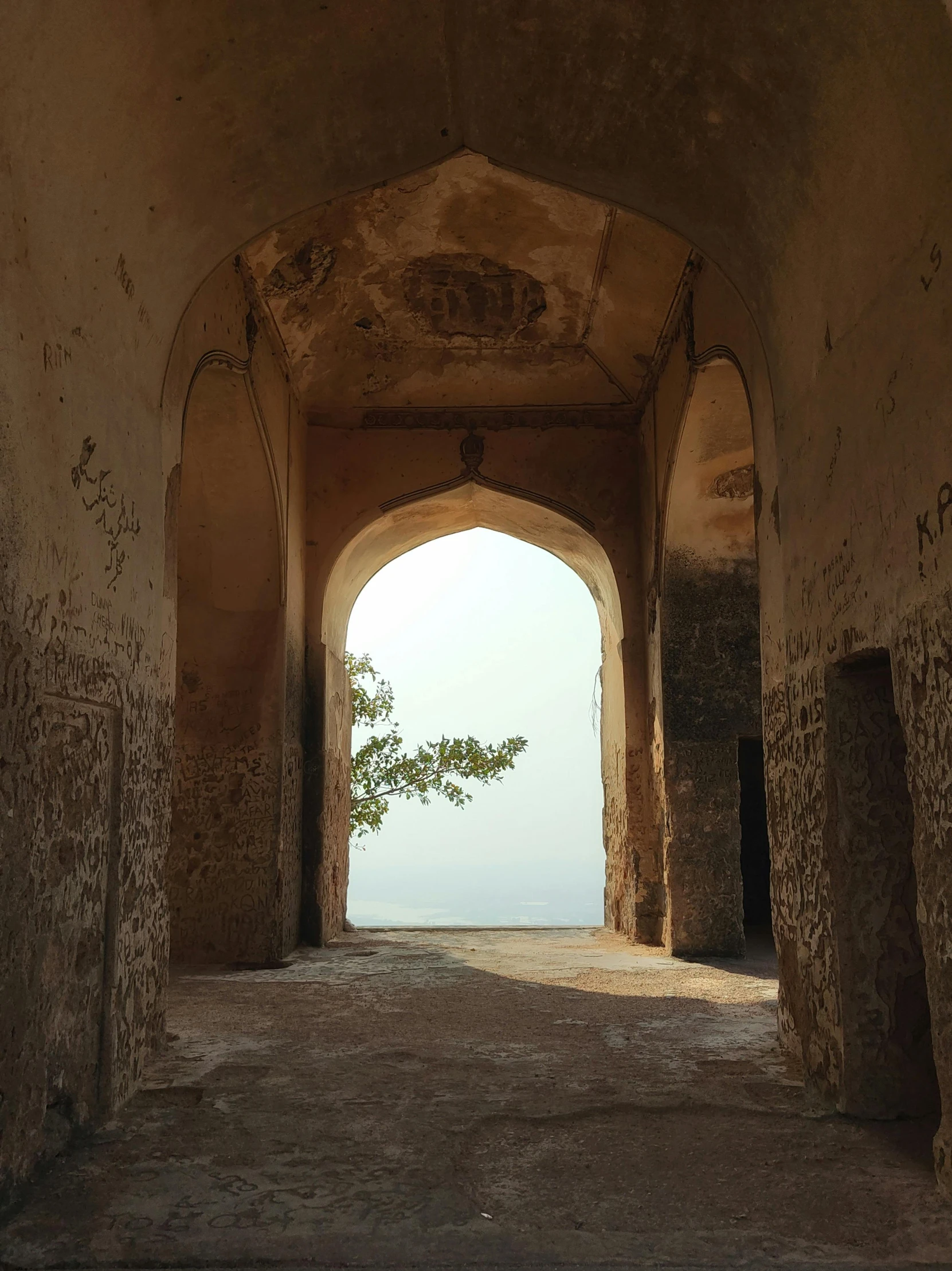 an archway in an old stone building leading to the ocean