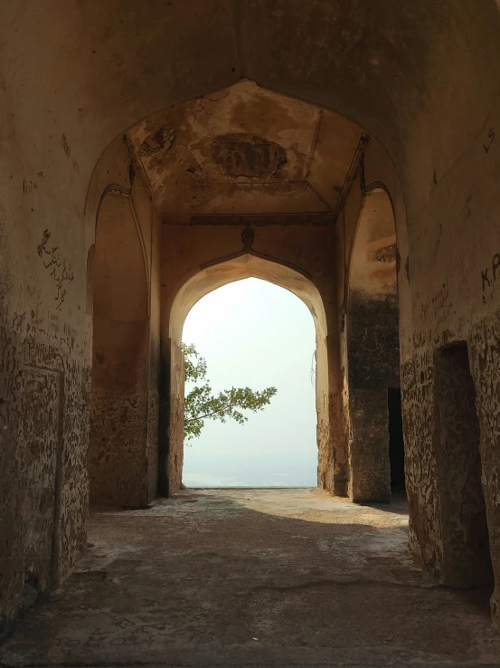 an archway in an old stone building leading to the ocean