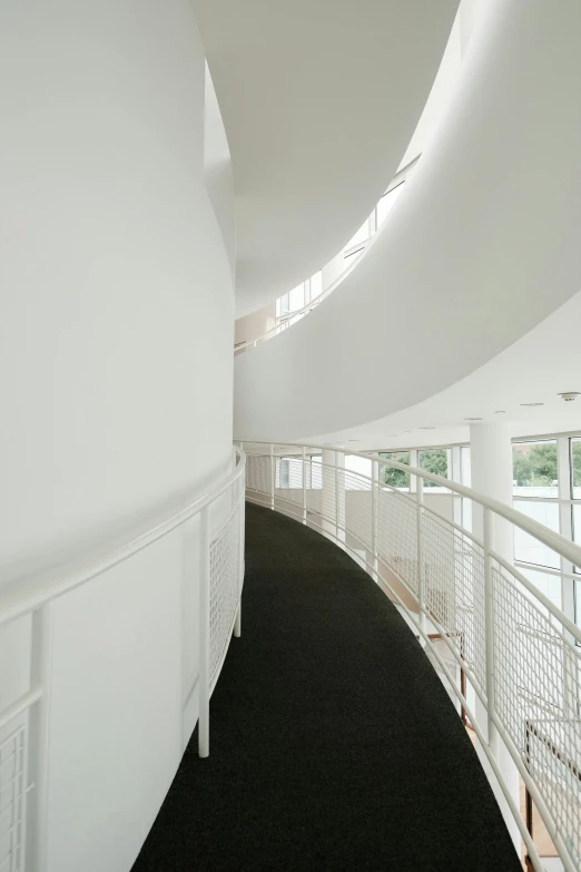 a curved staircase that has white railings