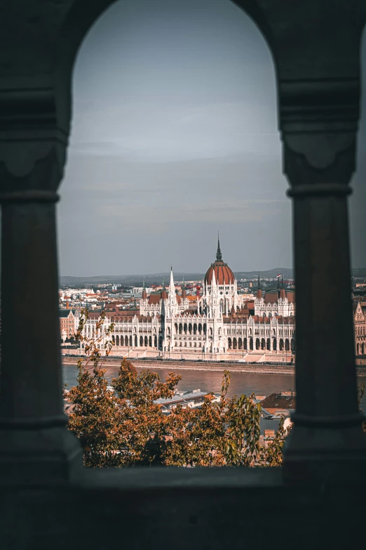 a city with buildings and water through a stone frame