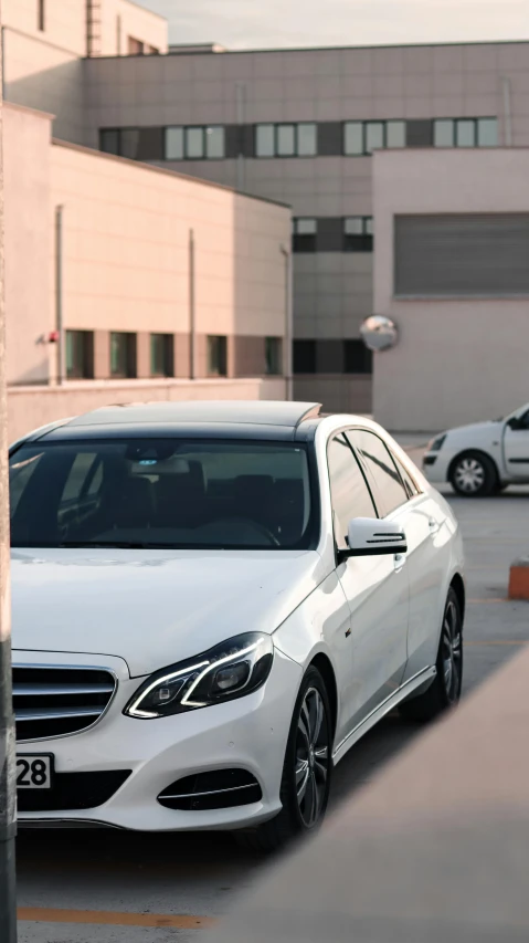 the front of a white car parked in a parking lot