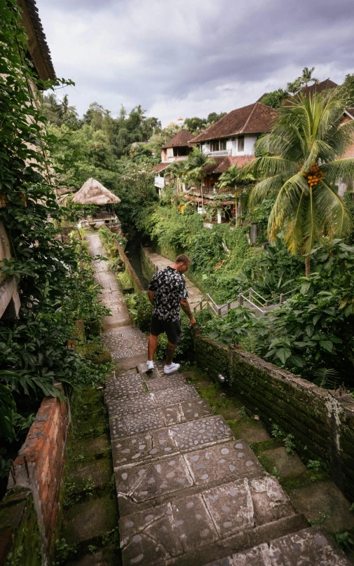 a man stands at the bottom of a brick walkway