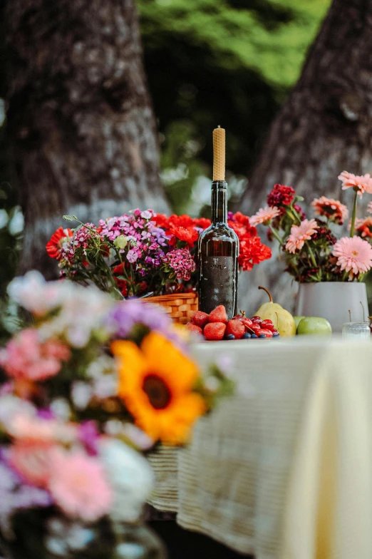 various flowers and a bottle of wine on a table