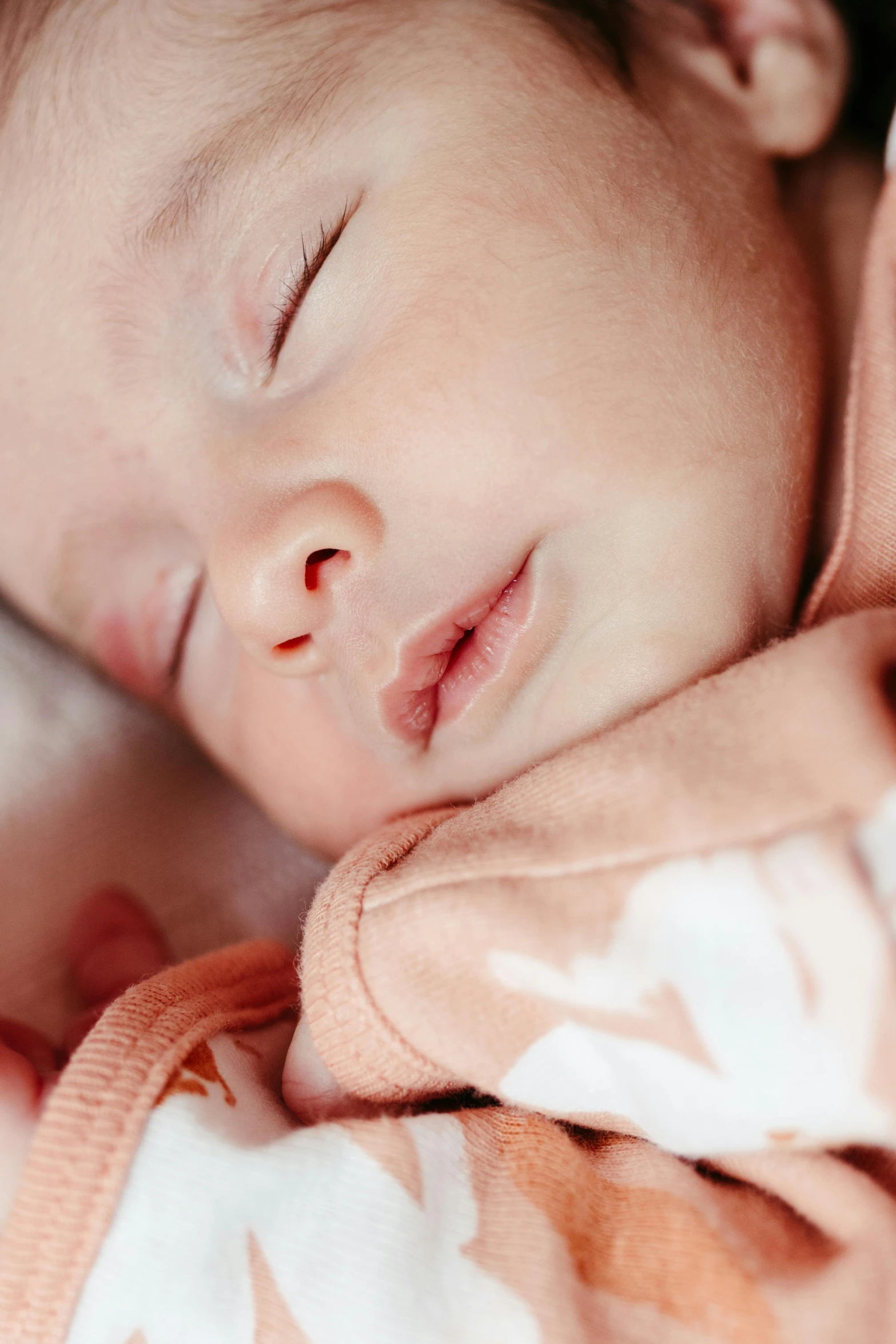 a newborn baby sleeps peacefully on a blanket