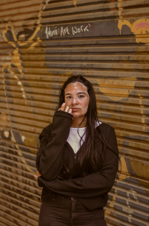 a woman poses in front of graffiti painted on a wall