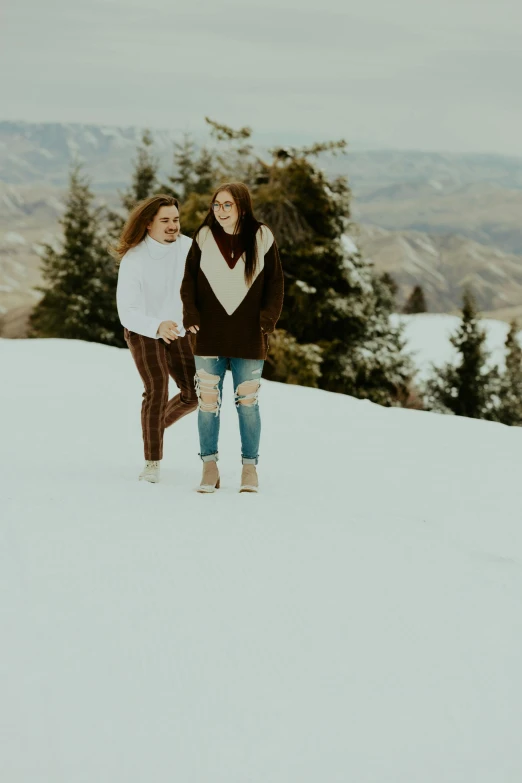 two women walking on top of a snow covered slope