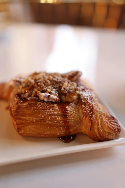 a pastry with nuts on top on a white plate