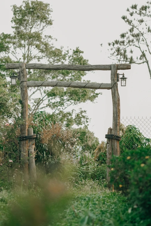 a wooden gate made of wood surrounded by shrubbery