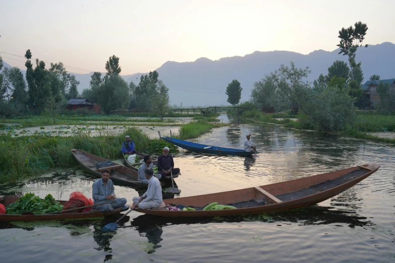 two small boats with people on them floating in water