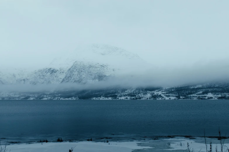 a mountain covered in snow and some clouds