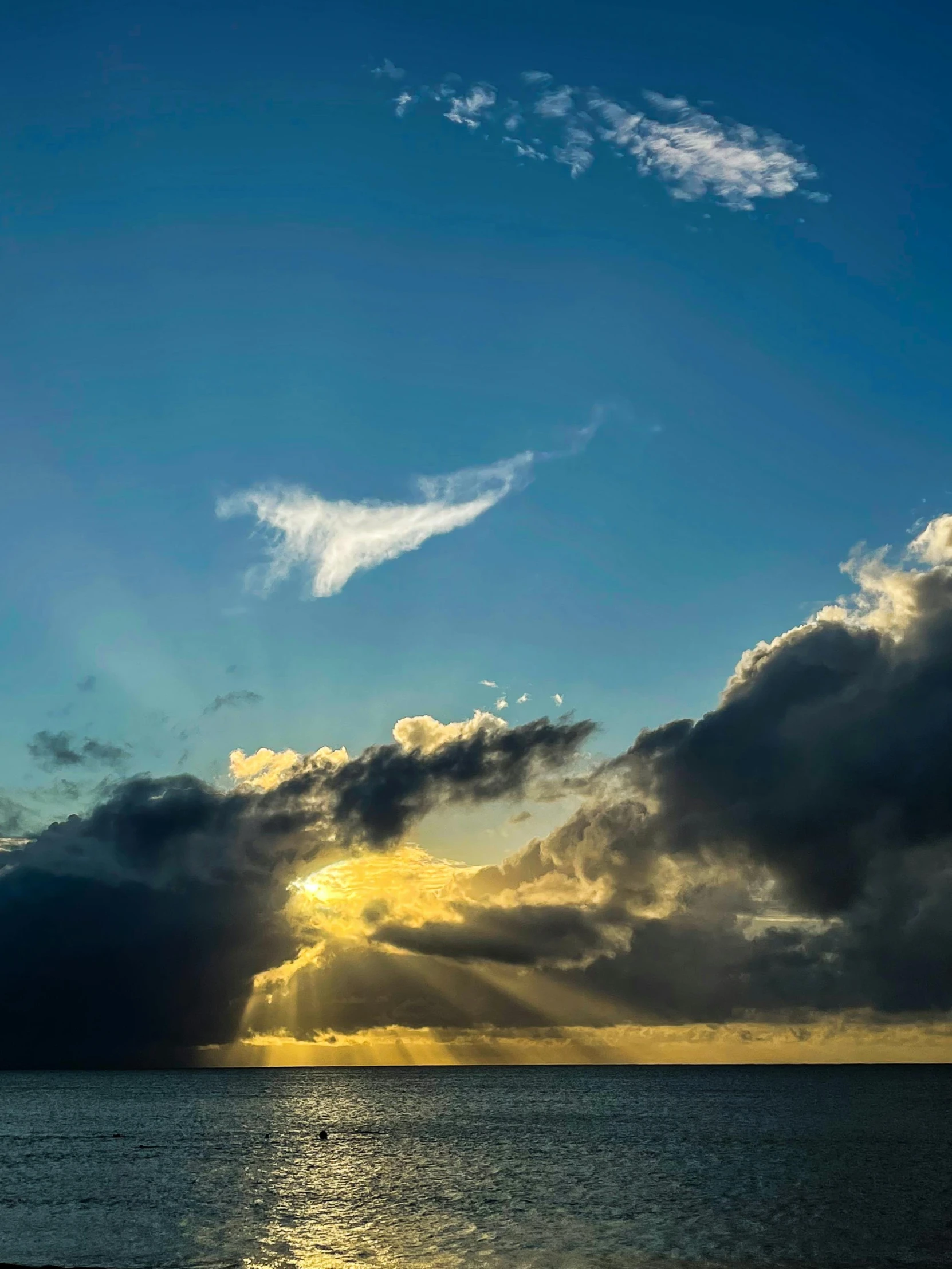 a plane flying in the clouds during a sunset