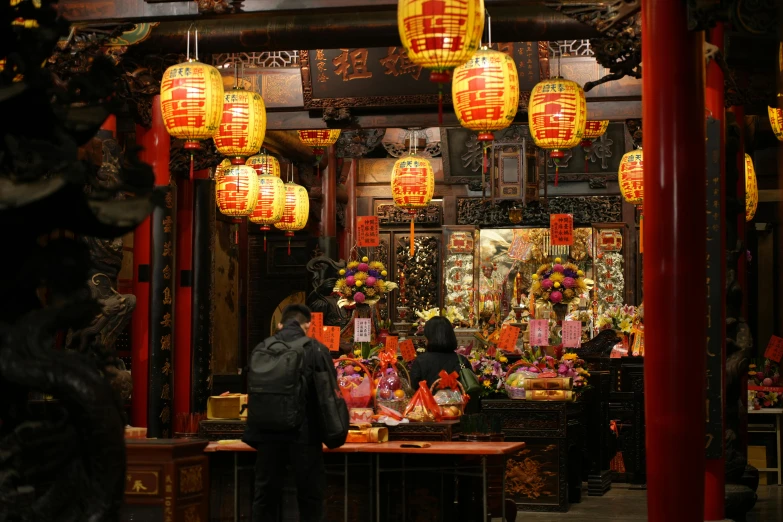 an asian shrine with a person standing in front of the altar