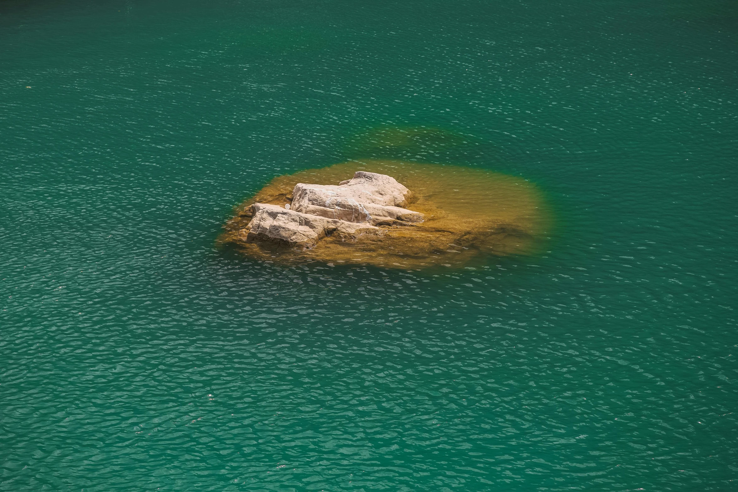 a small rock sits in a body of water