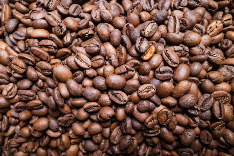 a pile of brown coffee beans sitting on top of each other