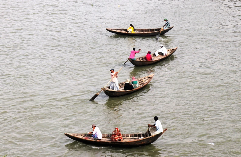 small boats being rowed in a large body of water