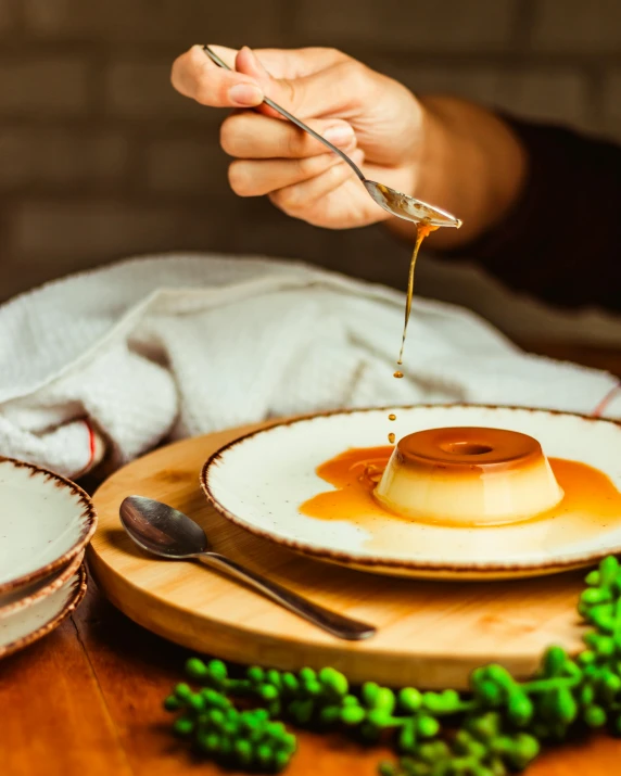 a hand drizzing honey on a plate