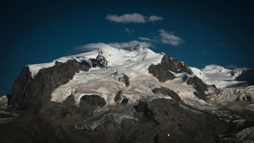 a group of mountains under a partly cloudy sky