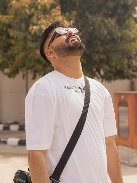 a man is smiling with his camera strap on