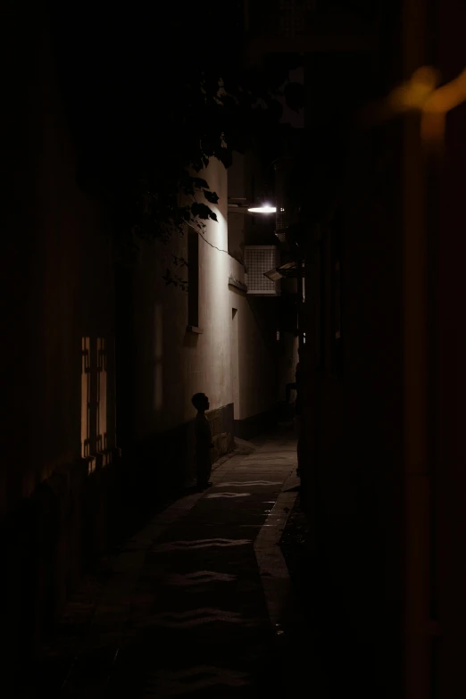 dark alley with person at the side with lamp on