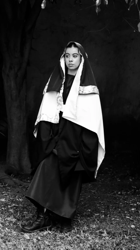 a young nun poses for a pograph by a tree