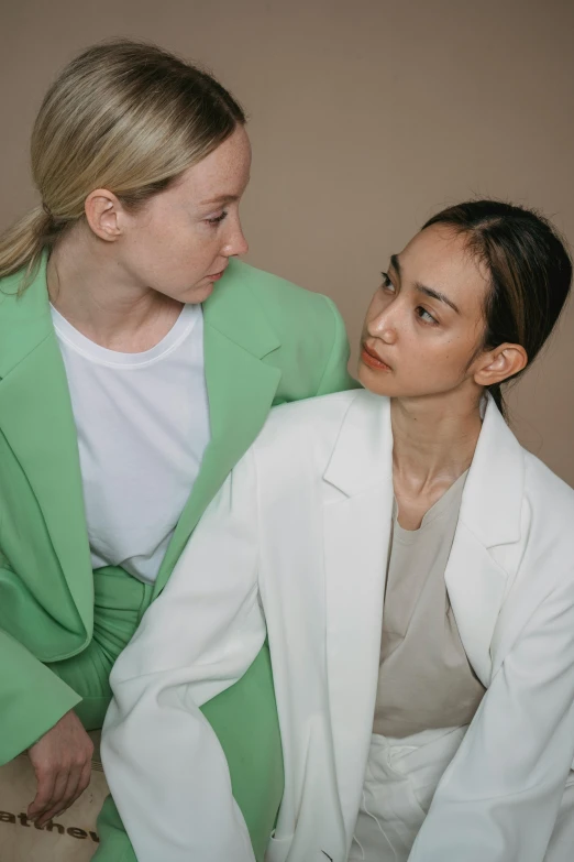 two women are sitting together, one is looking at the other