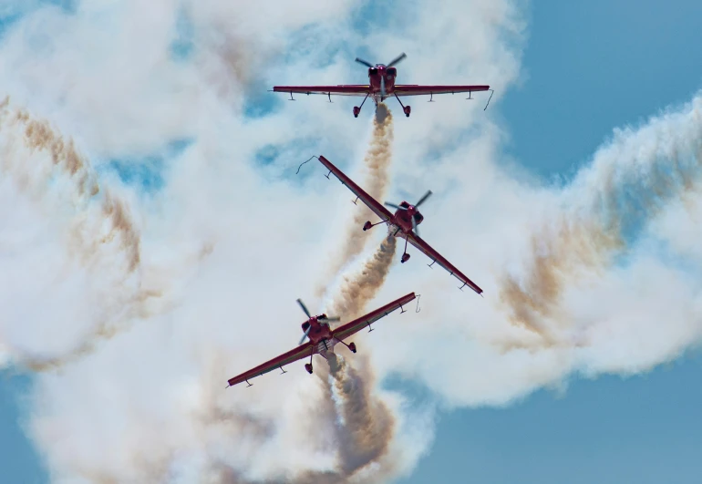 four airplanes making smoke as they fly in the sky