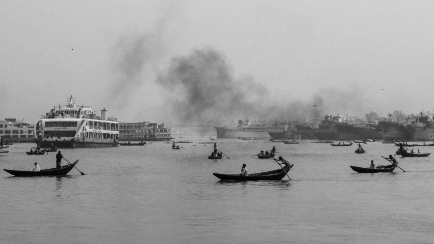 several boats in the water with smoke coming from them