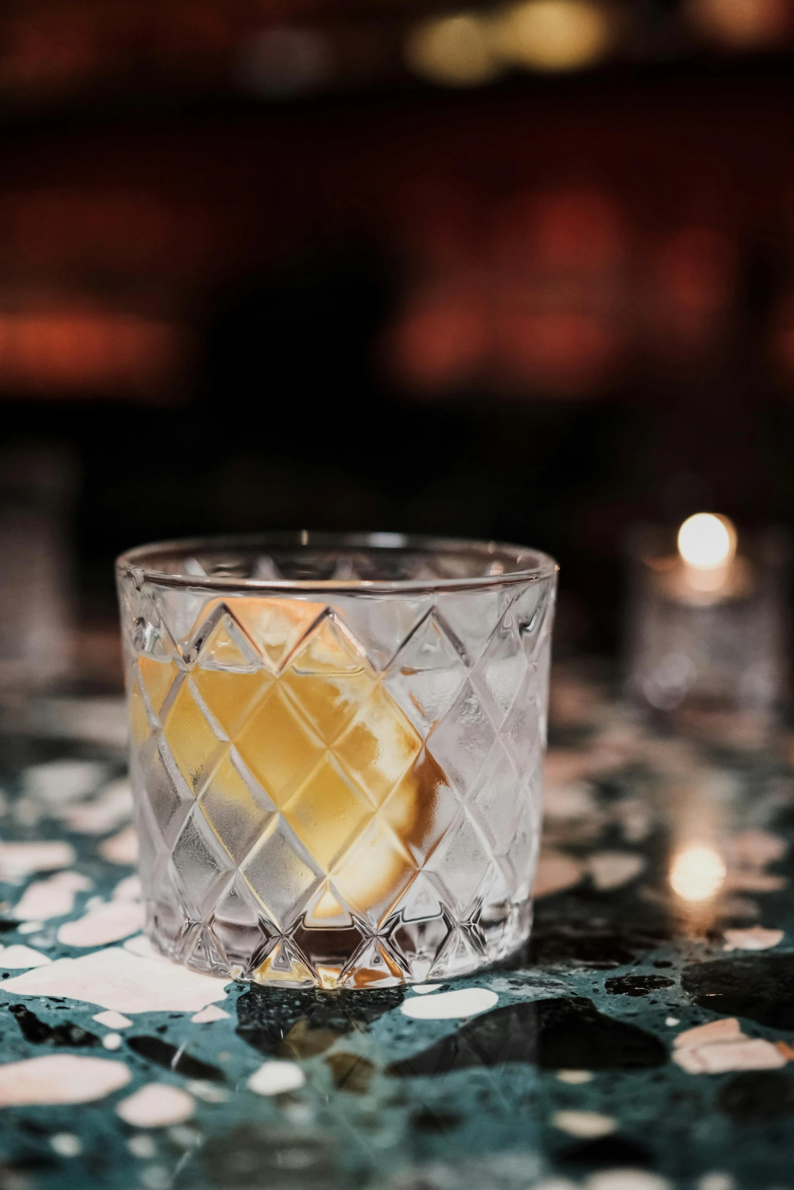 a glass filled with lemons on top of a table