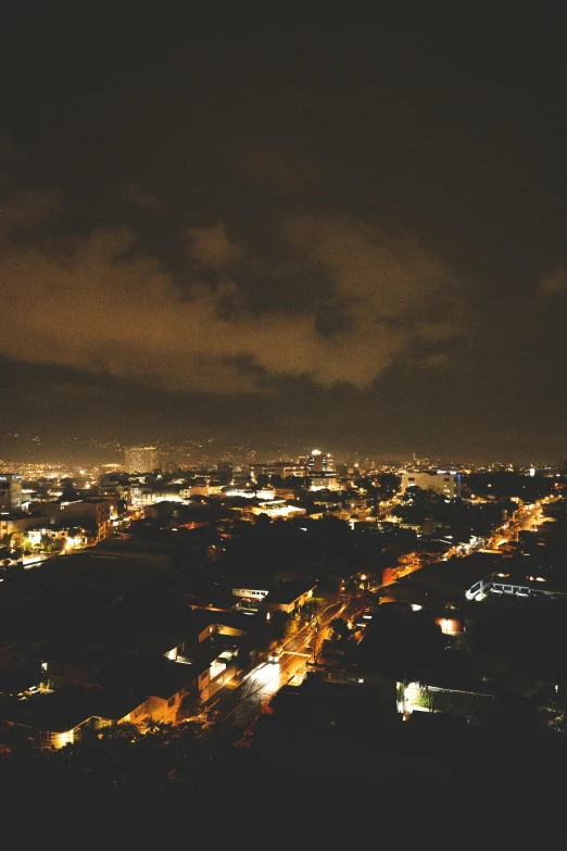 city lights in the distance seen from a hill top